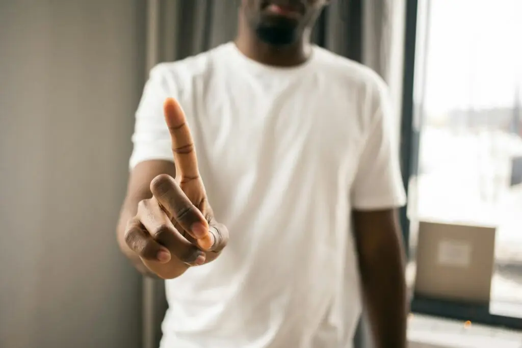 10 Essential Productivity Hacks for Writers, Ghostwriters, Copywriters, and Bloggers 4 Crop anonymous African American male in white t shirt showing stop gesture with index finger pointing up in light room on blurred background
