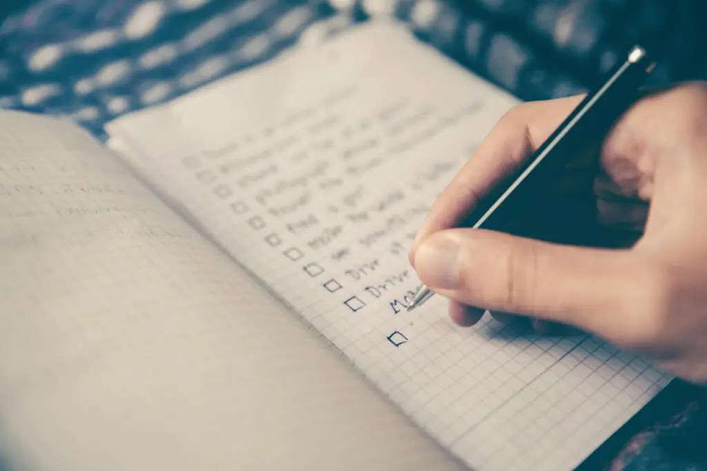 10 Essential Productivity Hacks for Writers, Ghostwriters, Copywriters, and Bloggers 2 person writing bucket list on book